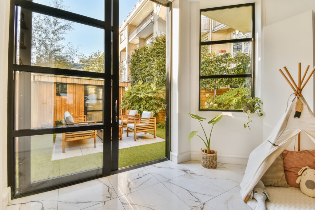 a living room with large glass doors and a backyard